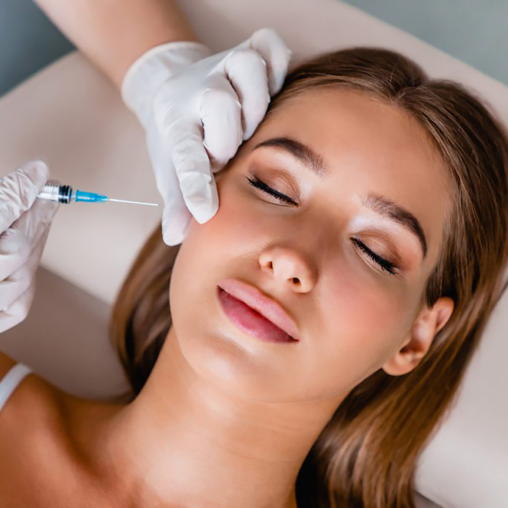 Woman patient receiving a cosmetic injection from a medical aesthetician for facial rejuvenation.