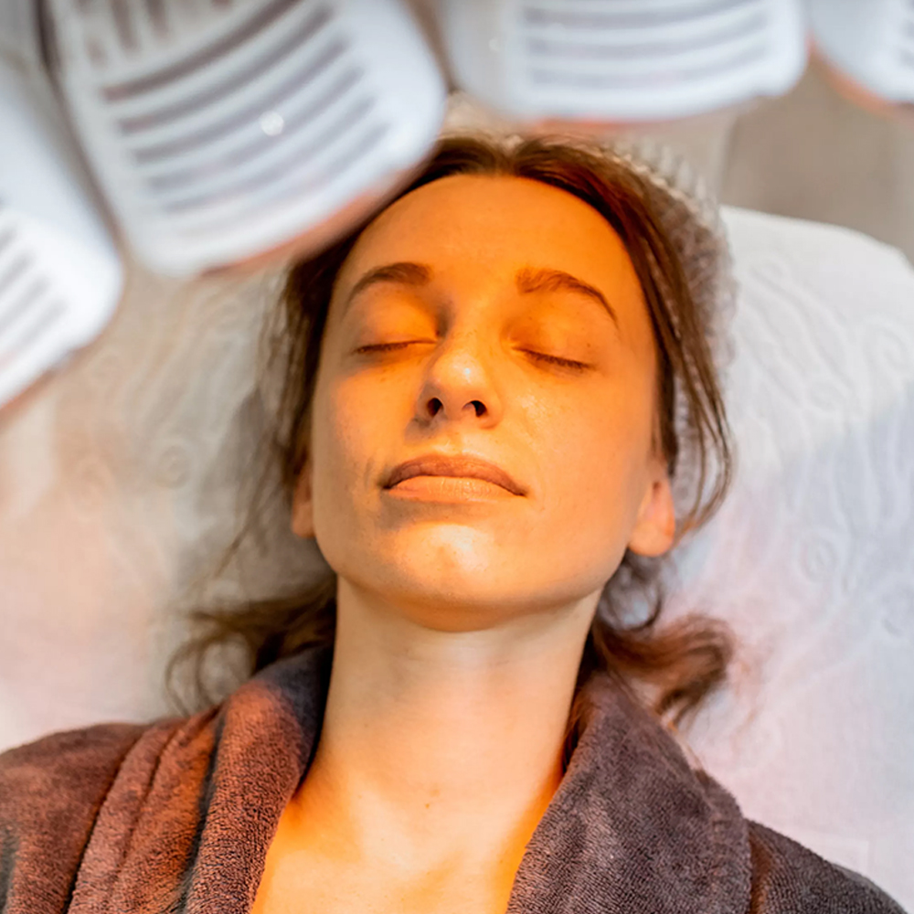 Content patient with a satisfied expression immediately after an LED light therapy session, highlighting no downtime.