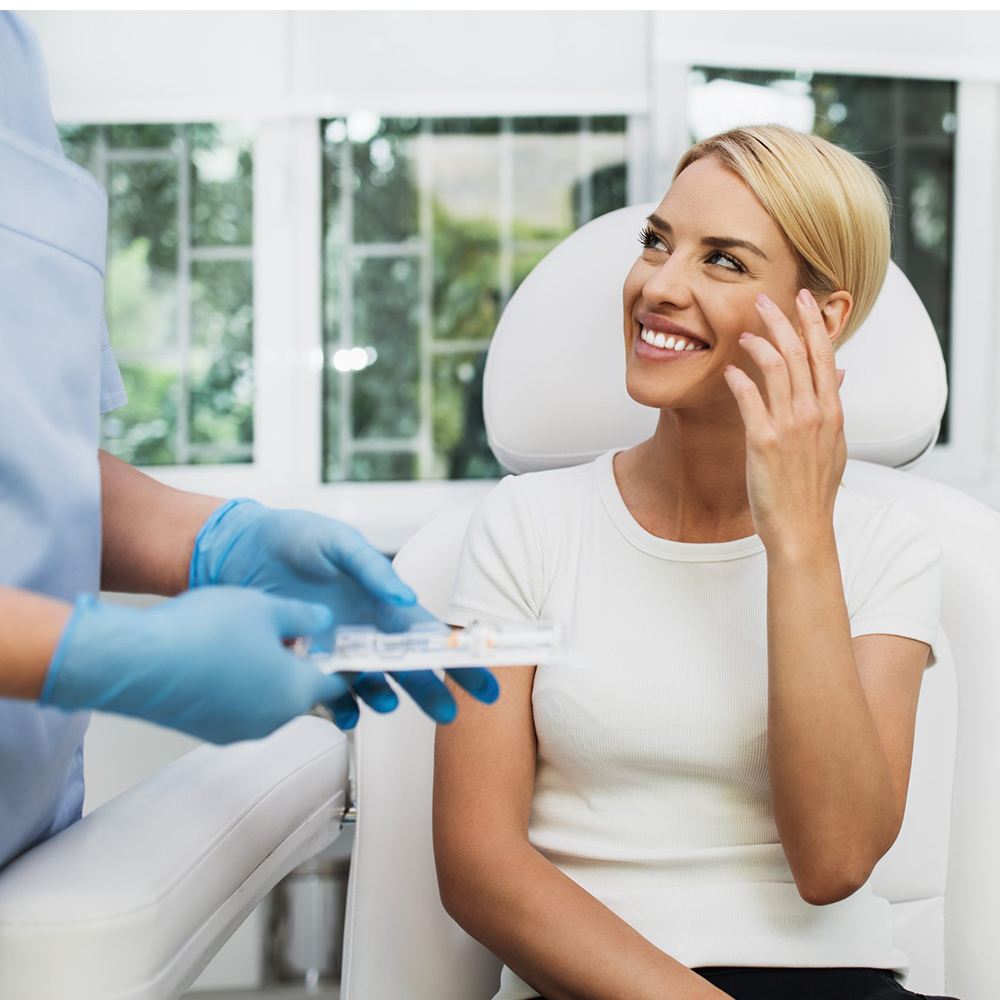 Woman smiling during after-treatment consultation with an aesthetician, showing satisfaction with Pepita Microdermabrasion results.