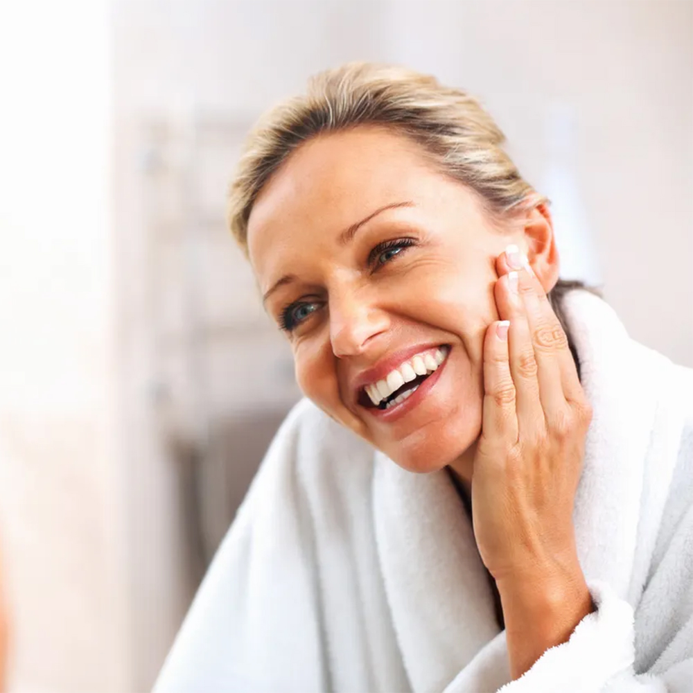 Woman smiling with flawless skin, showing immediate post-treatment results.